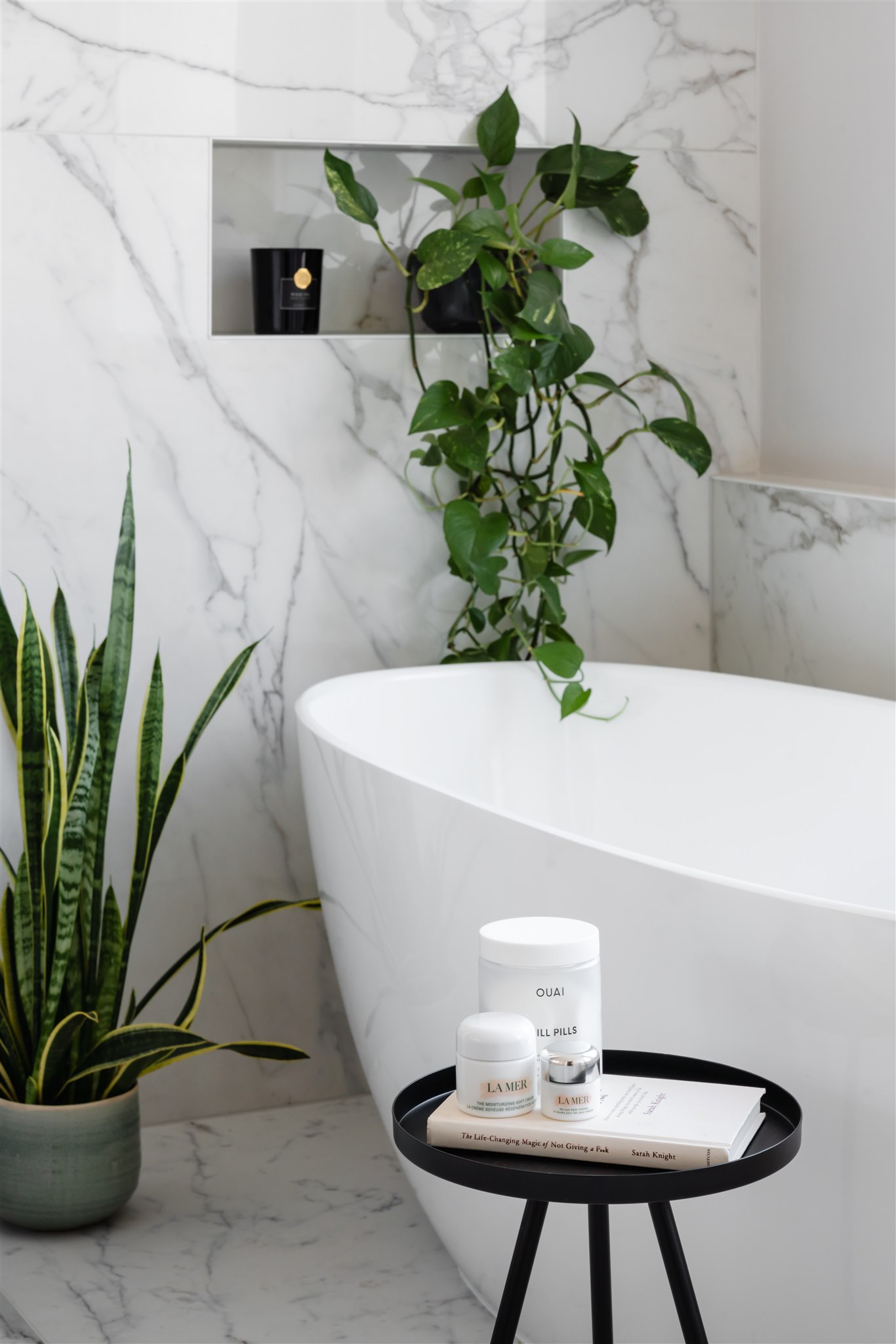 Spa-worthy design moments—natural greenery, niche shelving and layered textures—bring softness to this luxurious en suite bathroom. The sculpted freestanding bath by Victoria + Albert adds an elegant focal point, balancing heritage charm with modern indulgence.