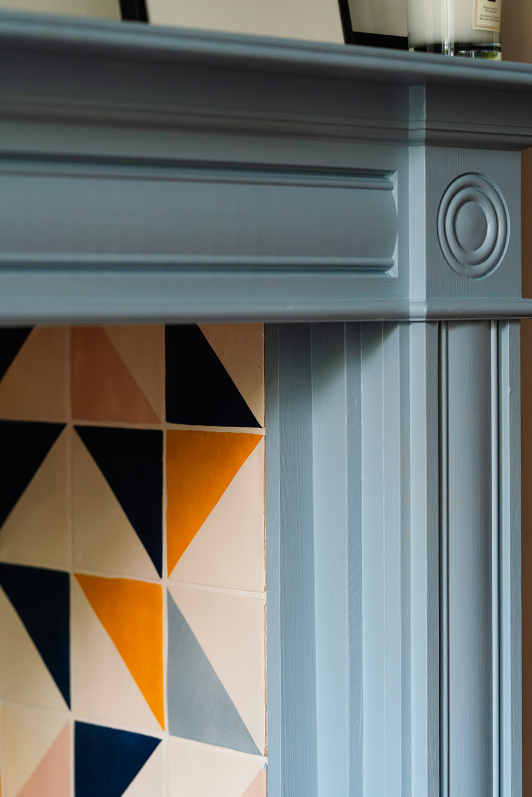 Sustainable fireplace design with handmade geometric tiles and eco-friendly paint in a London period property.