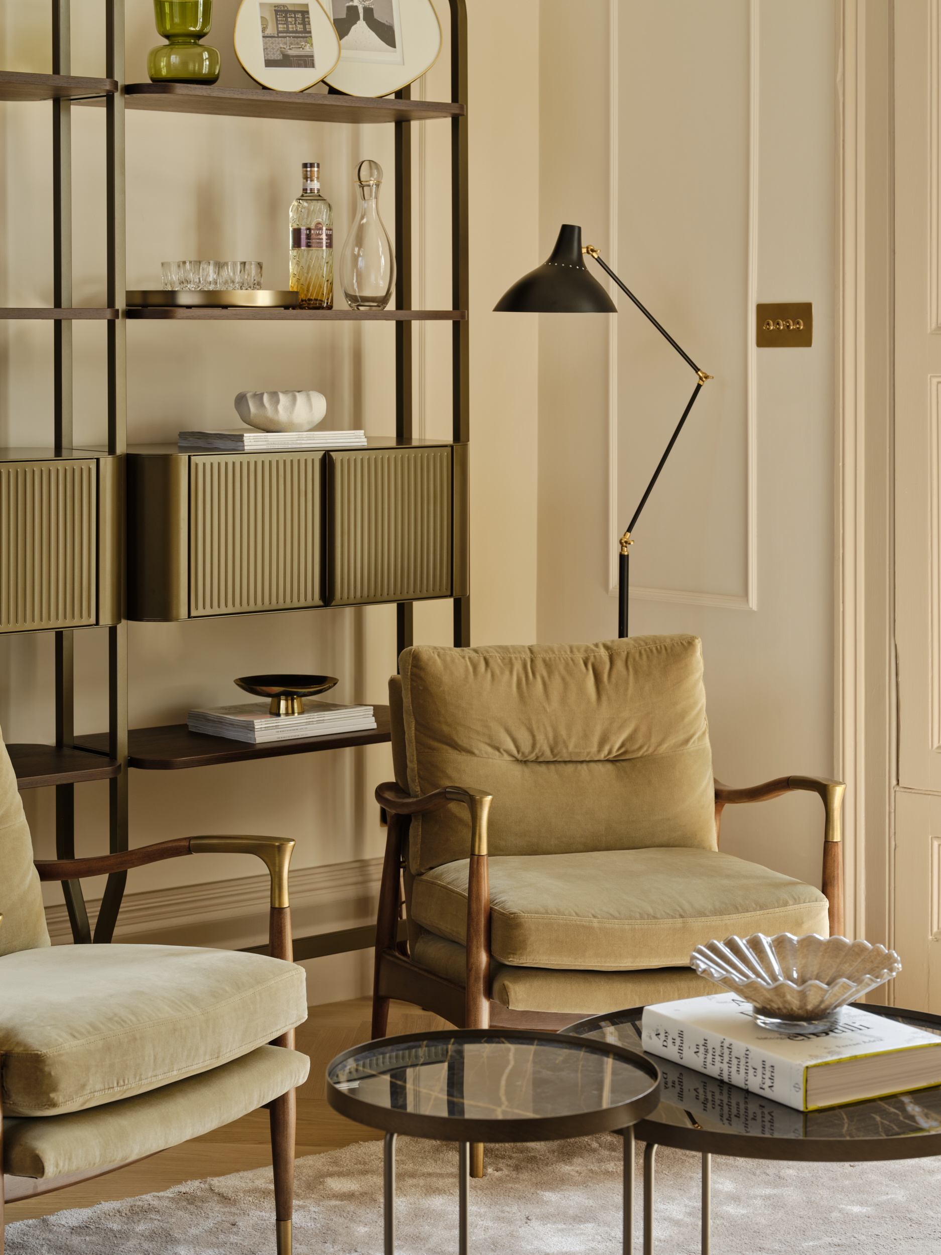 Neutral sitting room with velvet armchairs and modern shelving, representing affordable luxury and high-street home décor in London