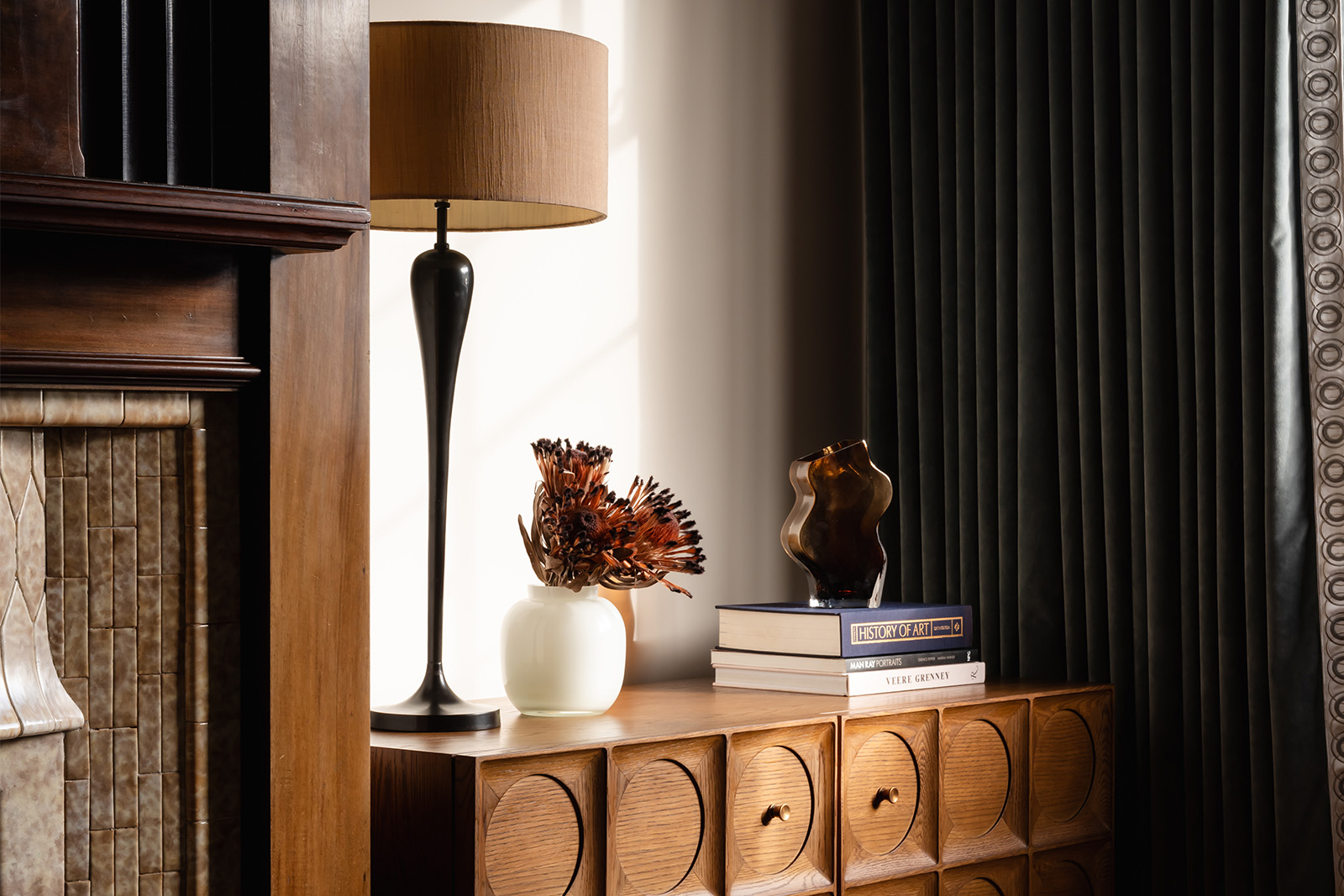 Art Deco fireplace styling with modern sideboard, sculptural lamp and dried floral arrangement in a Richmond home designed by Studio 3 Creatives.