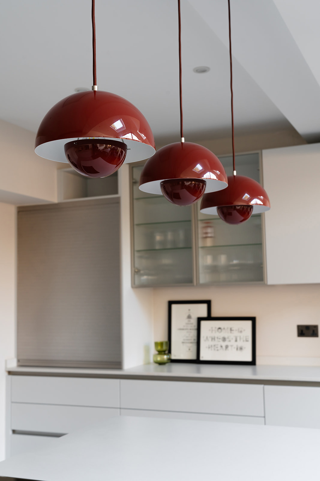 Modern red flowerpot pendant lights above kitchen island in a Richmond Art Deco renovation by Studio 3 Creatives.