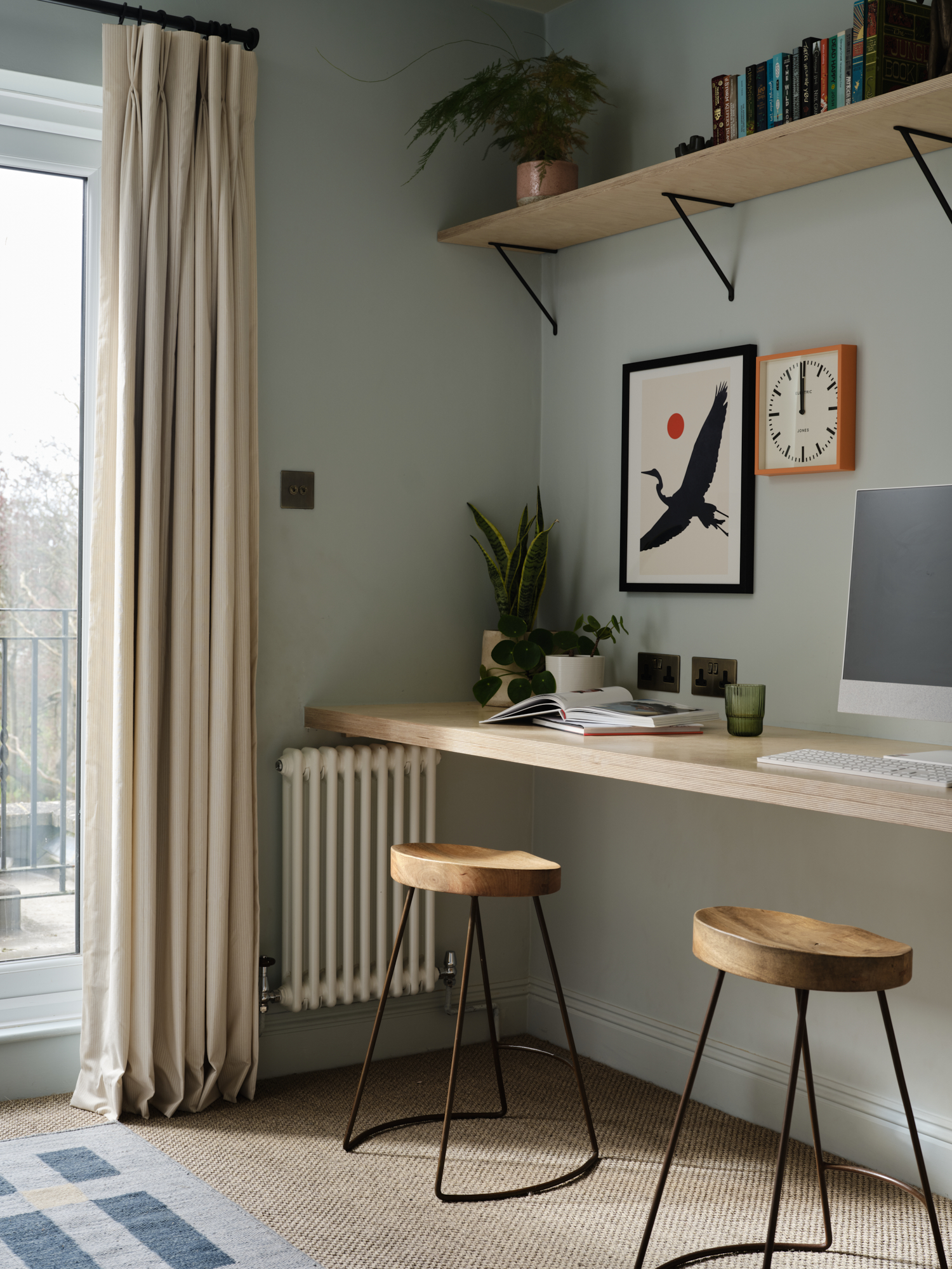 Home study with linen curtains framing balcony access and bespoke plywood desk, sage green walls St Margarets London