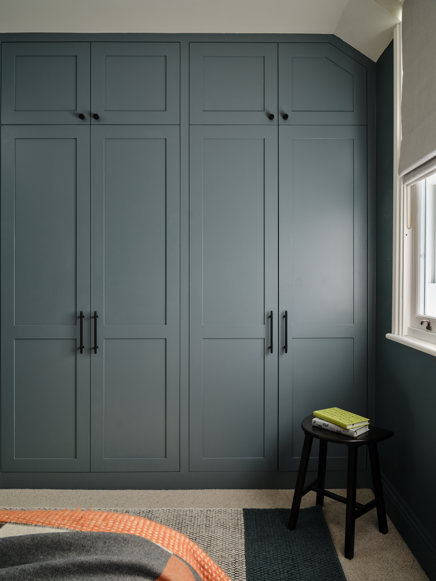 Bespoke fitted four-door wardrobe in teal grey with black handles and angled ceiling, teenage bedroom storage St Margarets London